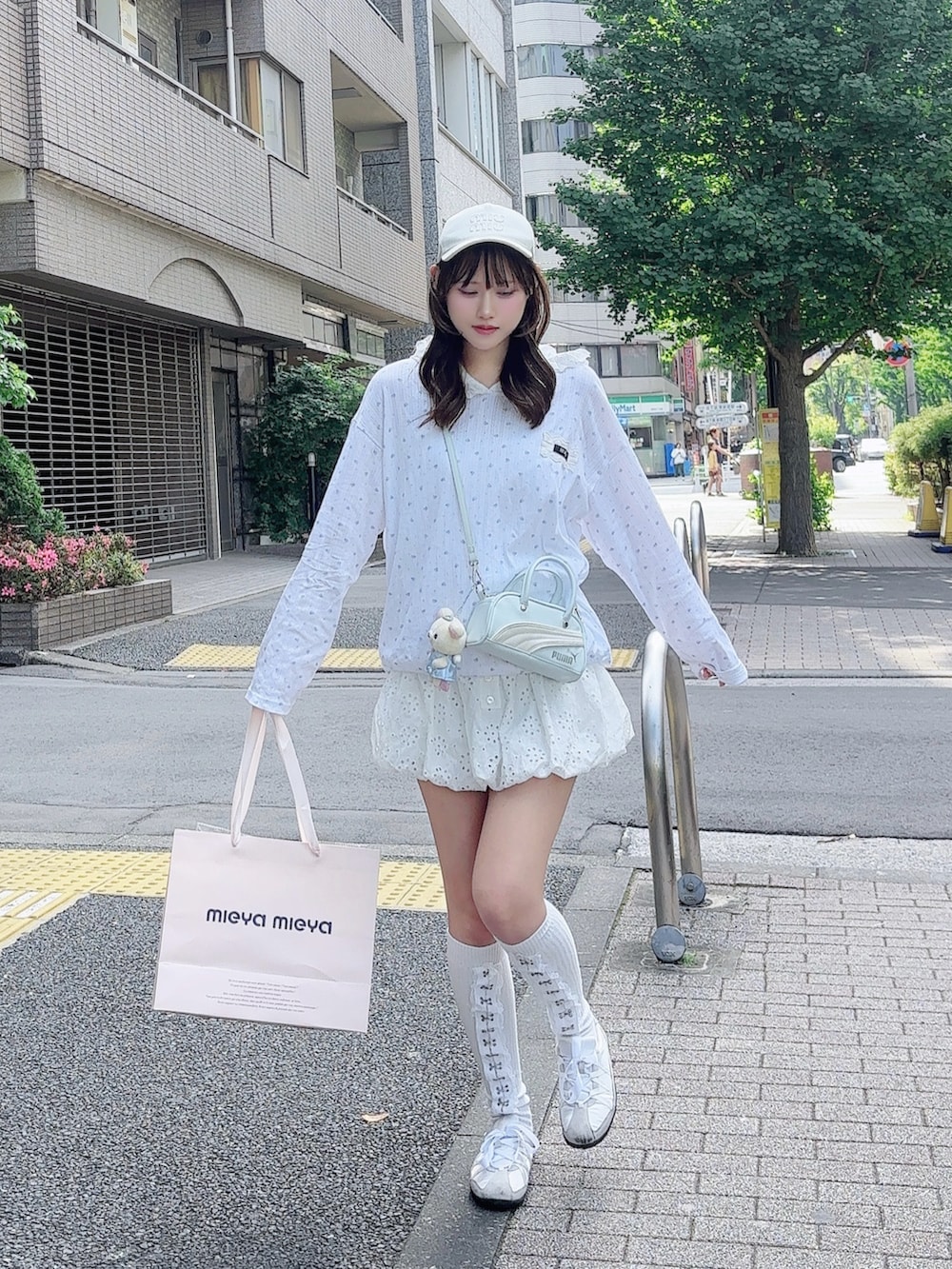 ホワイト系のTシャツ/カットソー、ブルー系のハンドバッグ、ホワイト系のパンツを着用したレディースの春コーディネートの2枚目の写真