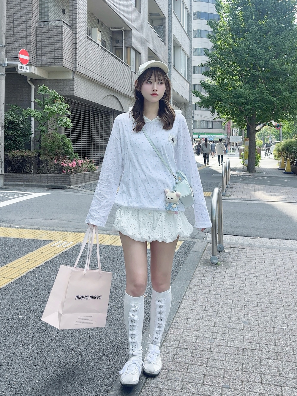 ホワイト系のTシャツ/カットソー、ブルー系のハンドバッグ、ホワイト系のパンツを着用したレディースの春コーディネートの3枚目の写真