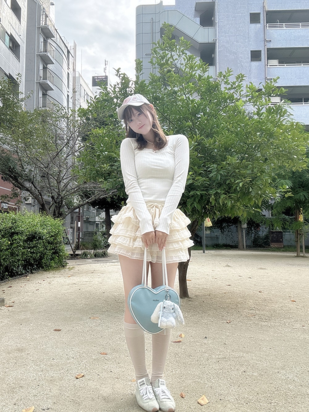 ホワイト系のトップス、ベージュ系のその他パンツ、ブルー系のスニーカーを着用したレディースの秋コーディネートの2枚目の写真