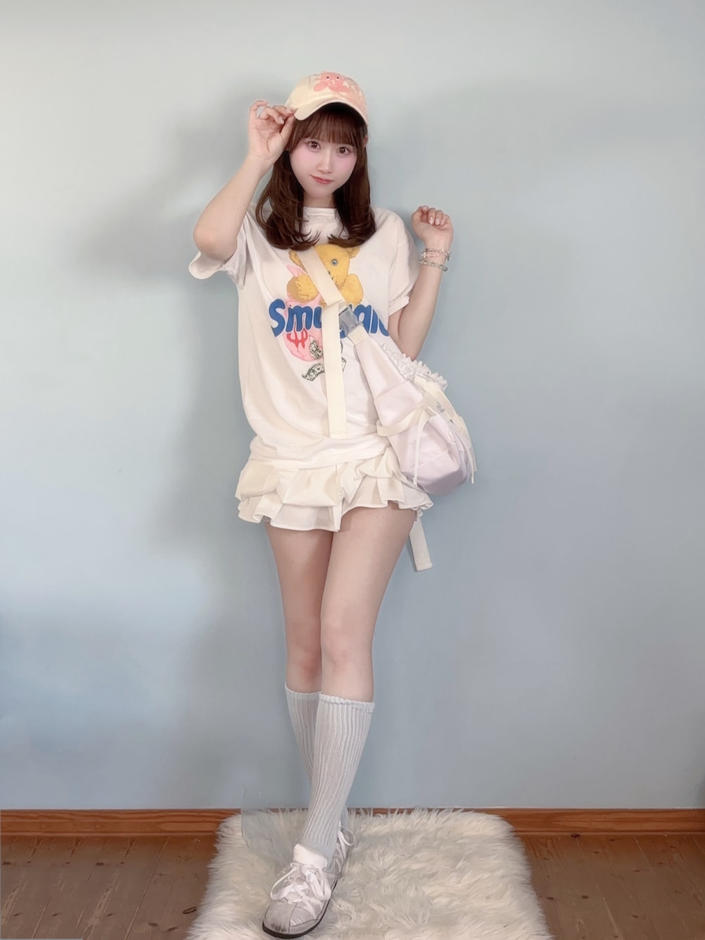 ホワイト系のスカート、ホワイト系のTシャツ/カットソー、ホワイト系のスニーカーを着用したレディースの春コーディネートの2枚目の写真
