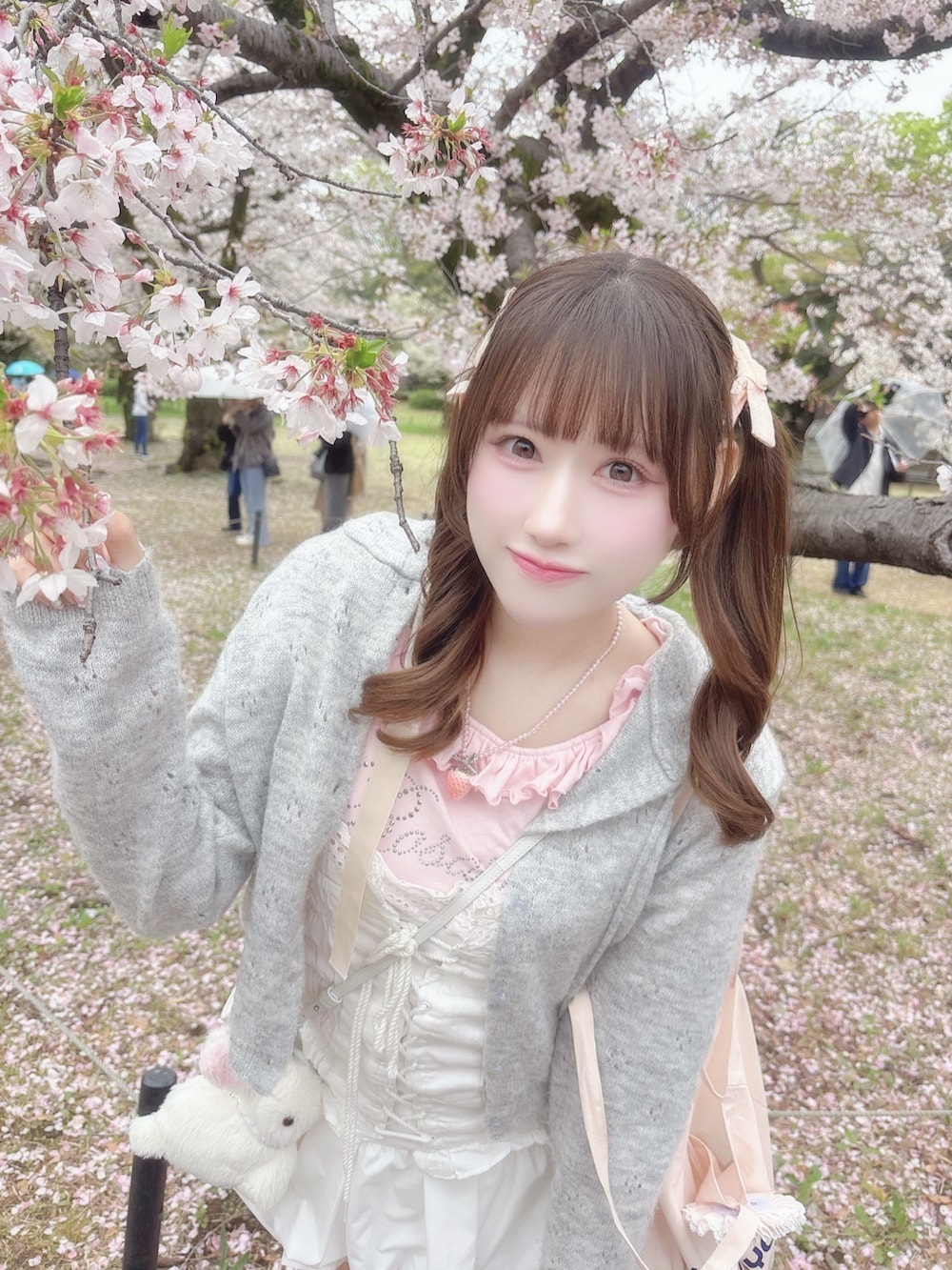 ホワイト系のトップス、ピンク系のTシャツ/カットソー、グレー系のカーディガン/ボレロを着用したレディースの春コーディネートの4枚目の写真