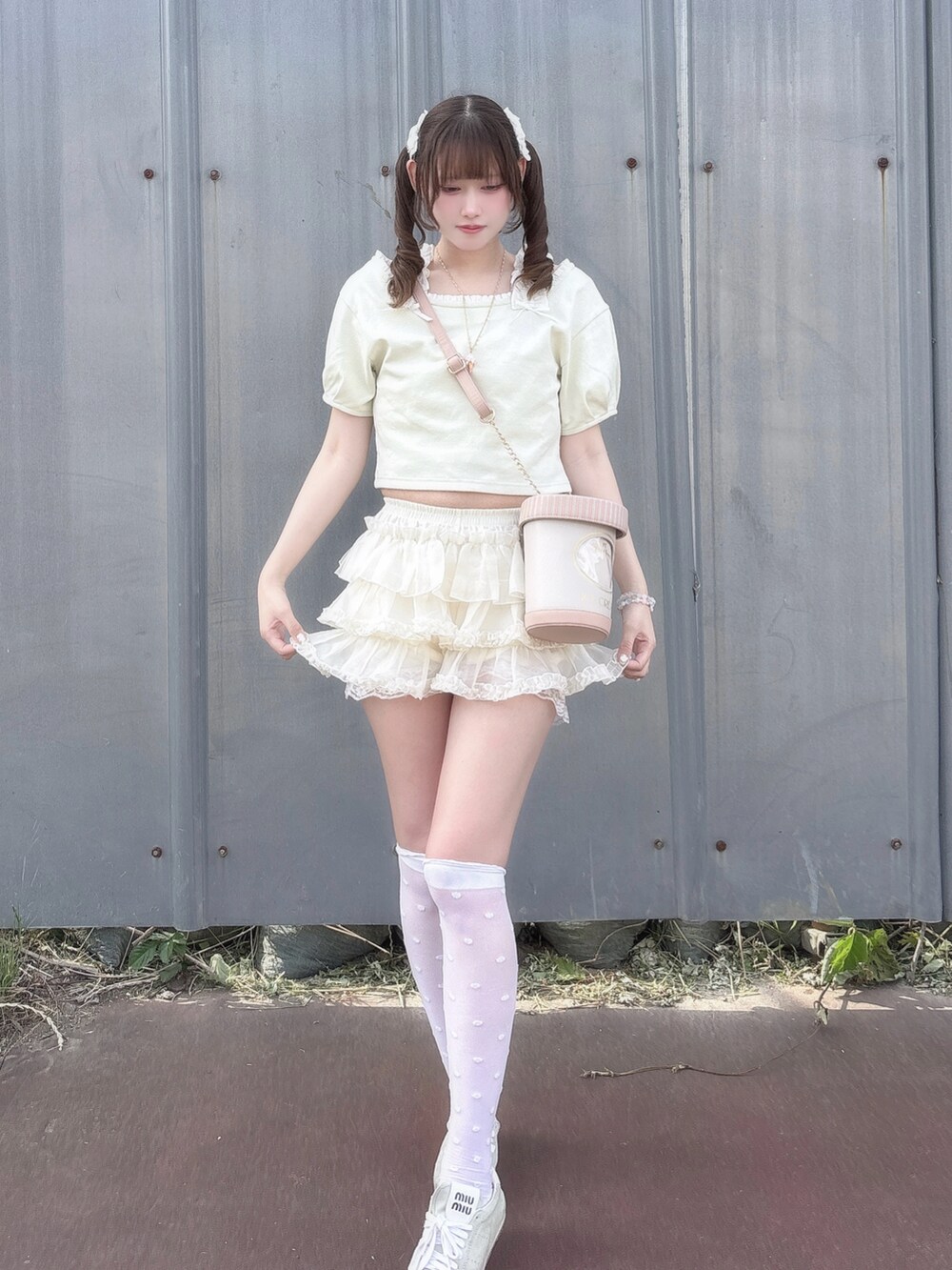 グリーン系のTシャツ/カットソー、ホワイト系のスカート、ピンク系のショルダーバッグを着用したレディースの夏コーディネートの3枚目の写真