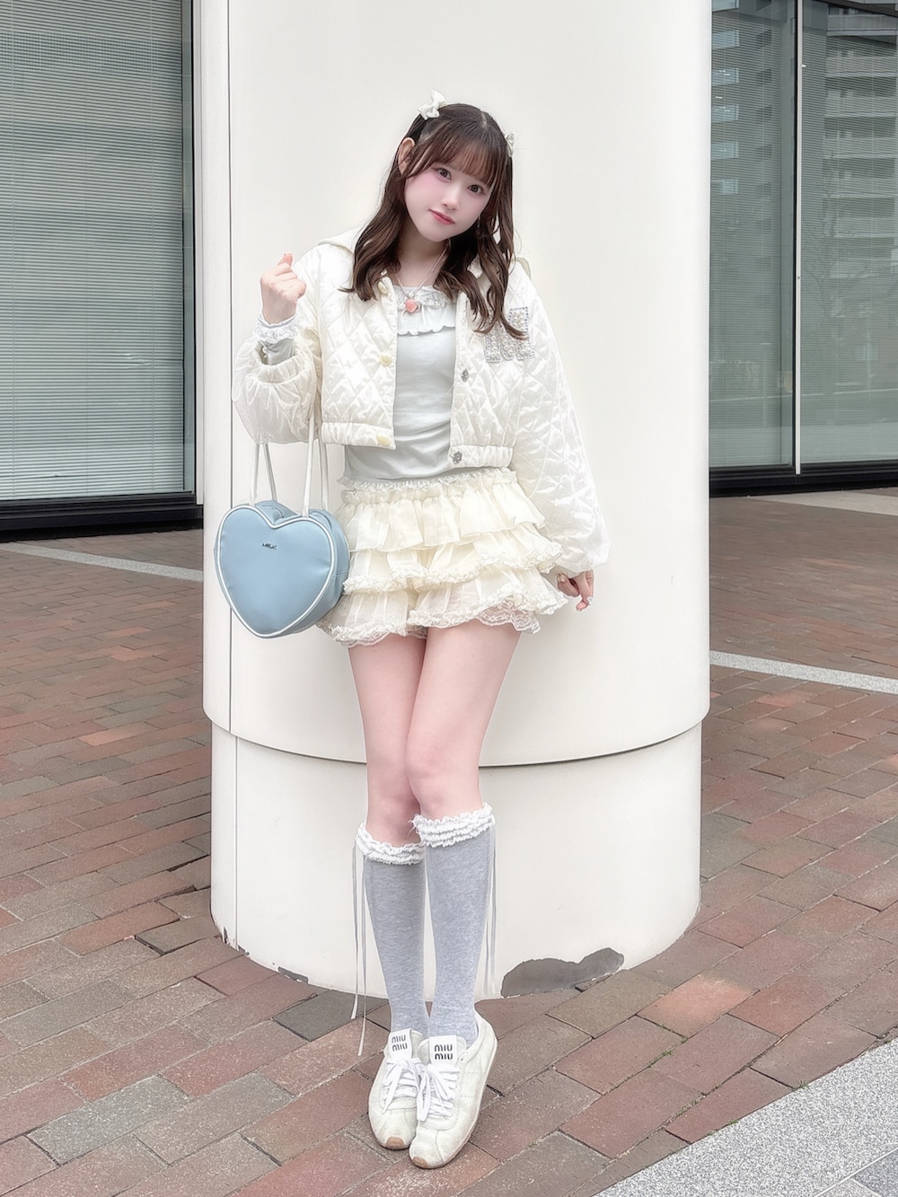 グリーン系のTシャツ/カットソー、ホワイト系のスカート、ブルー系のバッグを着用したレディースの冬コーディネートの2枚目の写真