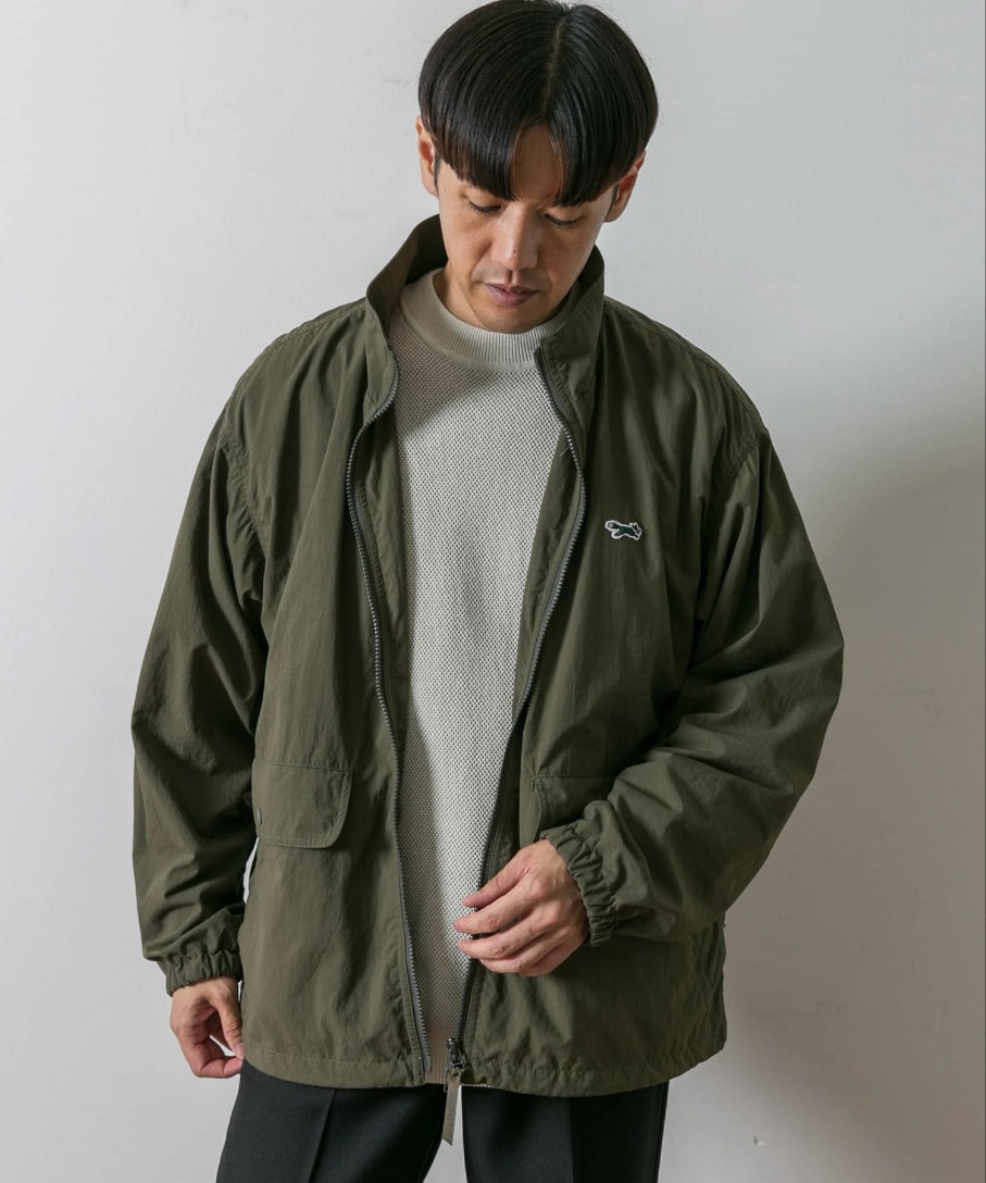 グリーン系のナイロンジャケット、ブラック系のその他パンツを着用したメンズの秋コーディネートの2枚目の写真