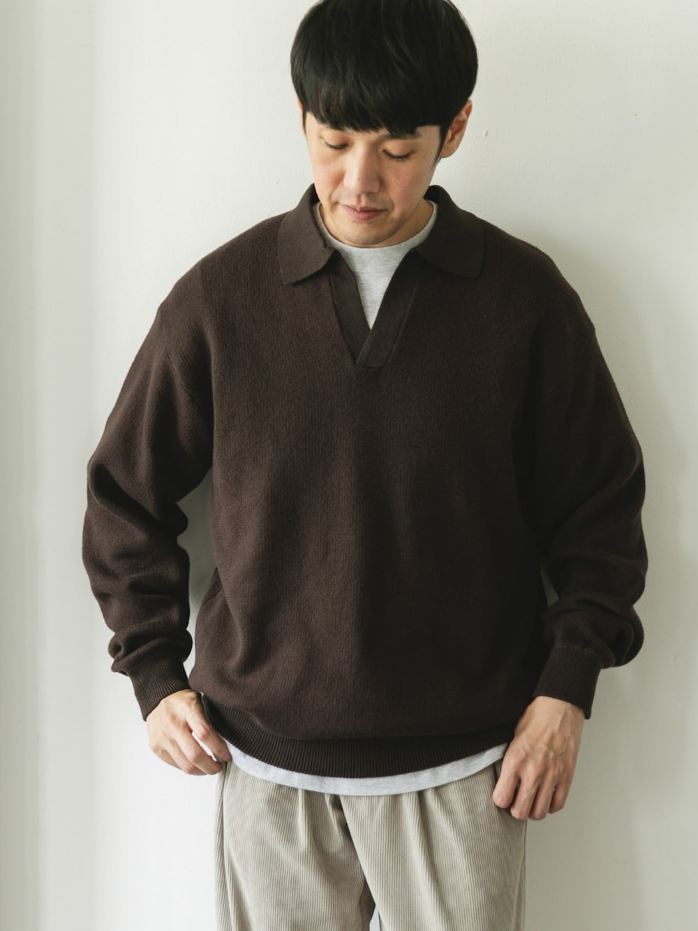 ブラウン系のニット/セーターを着用したメンズの秋コーディネートの2枚目の写真