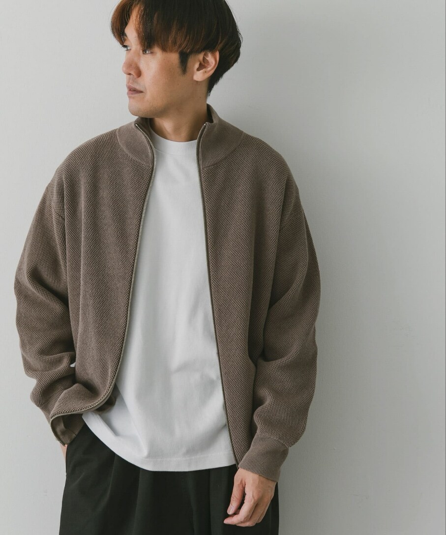 ブラウン系のブルゾン、ホワイト系のTシャツ/カットソー、ブラック系のチノパンツを着用したメンズの秋コーディネートの2枚目の写真