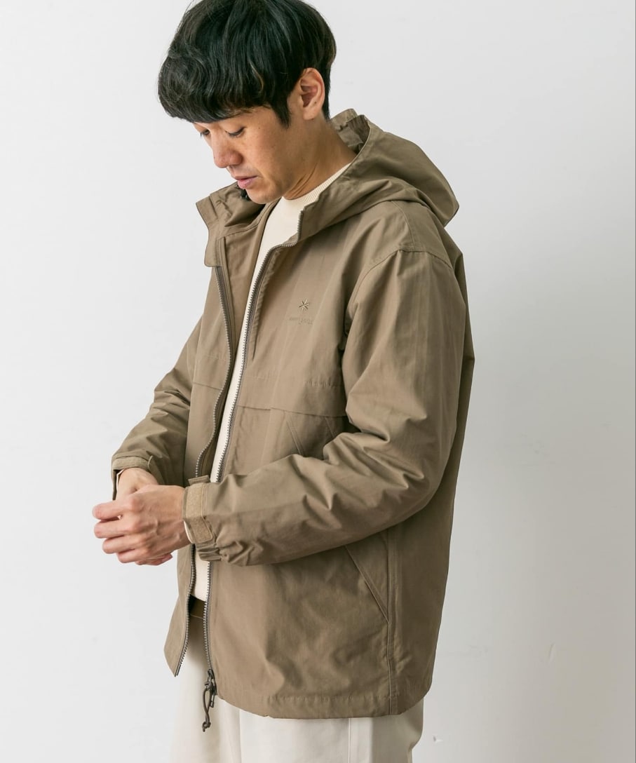 ベージュ系のマウンテンパーカー、ホワイト系のスニーカーを着用したメンズの冬コーディネートの2枚目の写真