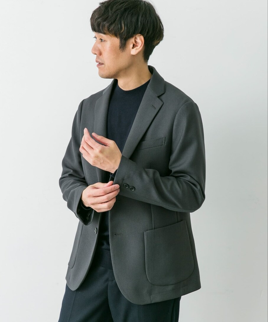 グレー系のスーツジャケット、ブルー系のニット/セーターを着用したメンズの冬コーディネートの2枚目の写真