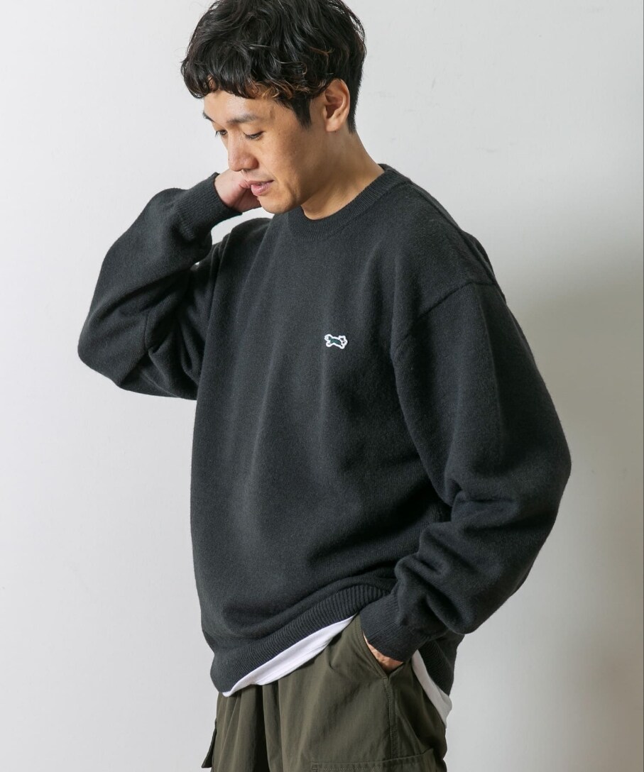 グレー系のニット/セーター、グリーン系のカーゴパンツを着用したメンズの秋コーディネートの2枚目の写真