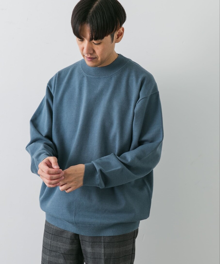 ブルー系のニット/セーター、グレー系のその他パンツを着用したメンズの秋コーディネートの2枚目の写真