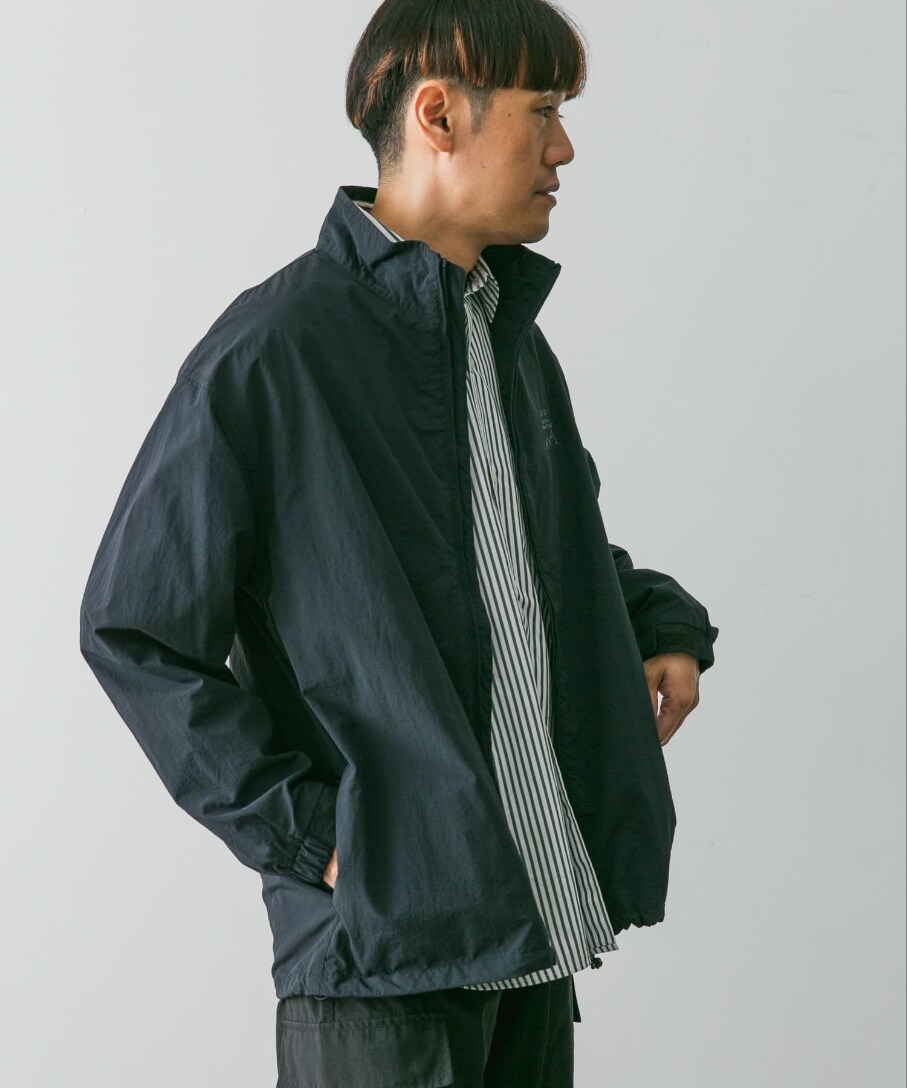 ブルー系のブルゾン、ブラック系のカーゴパンツを着用したメンズの秋コーディネートの2枚目の写真