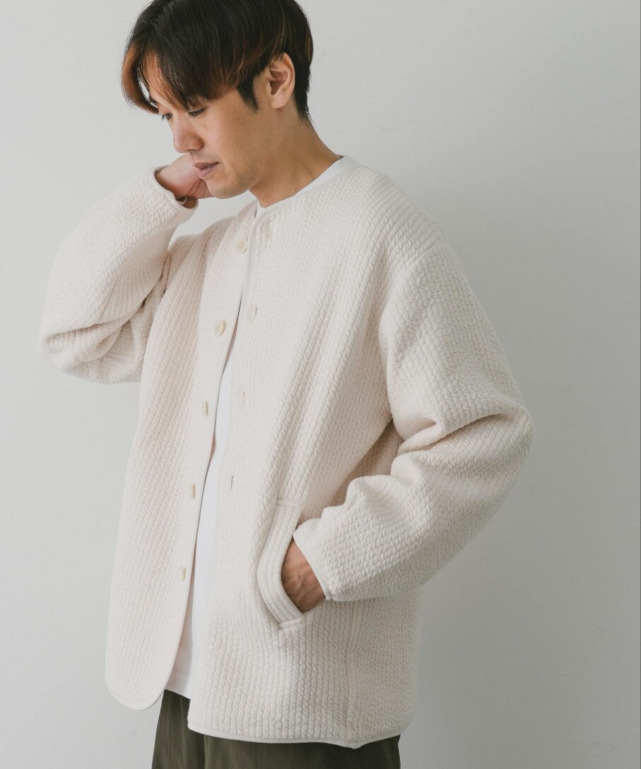 ホワイト系のブルゾン、グリーン系のカーゴパンツ、ホワイト系のTシャツ/カットソーを着用したメンズの秋コーディネートの2枚目の写真