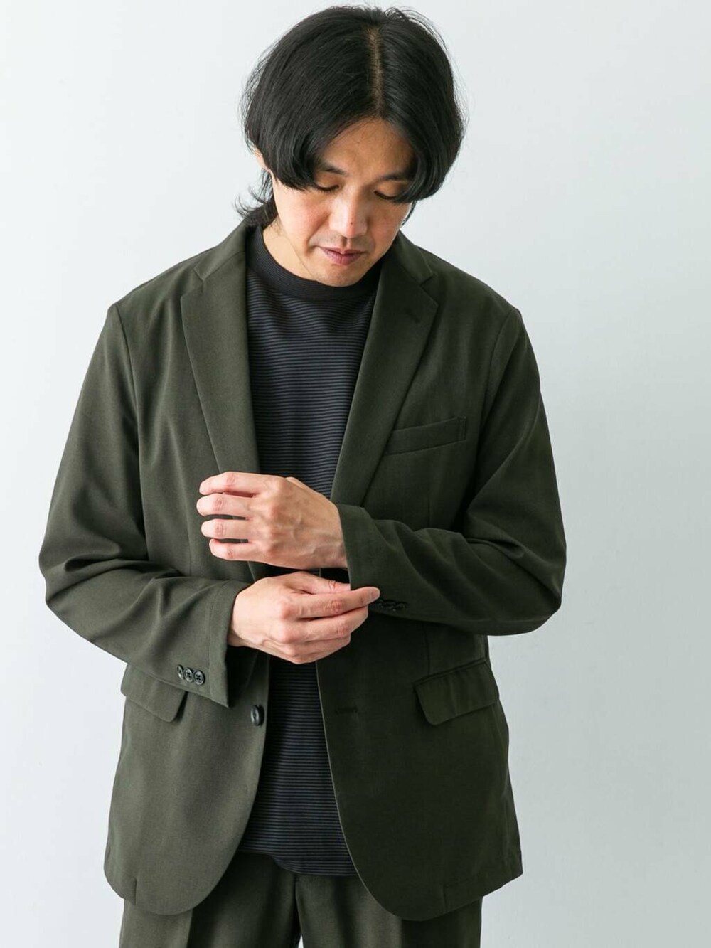 ブラック系のシャツ/ブラウス、グリーン系のスーツパンツ、グリーン系のスーツジャケットを着用したメンズの夏コーディネートの2枚目の写真