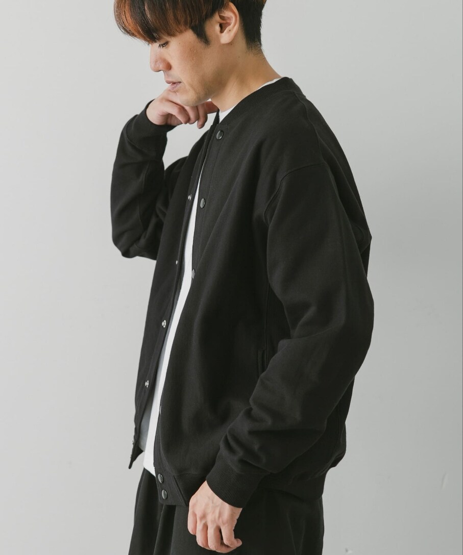 ブラック系のブルゾン、ホワイト系のTシャツ/カットソー、ブラック系のチノパンツを着用したメンズの秋コーディネートの3枚目の写真