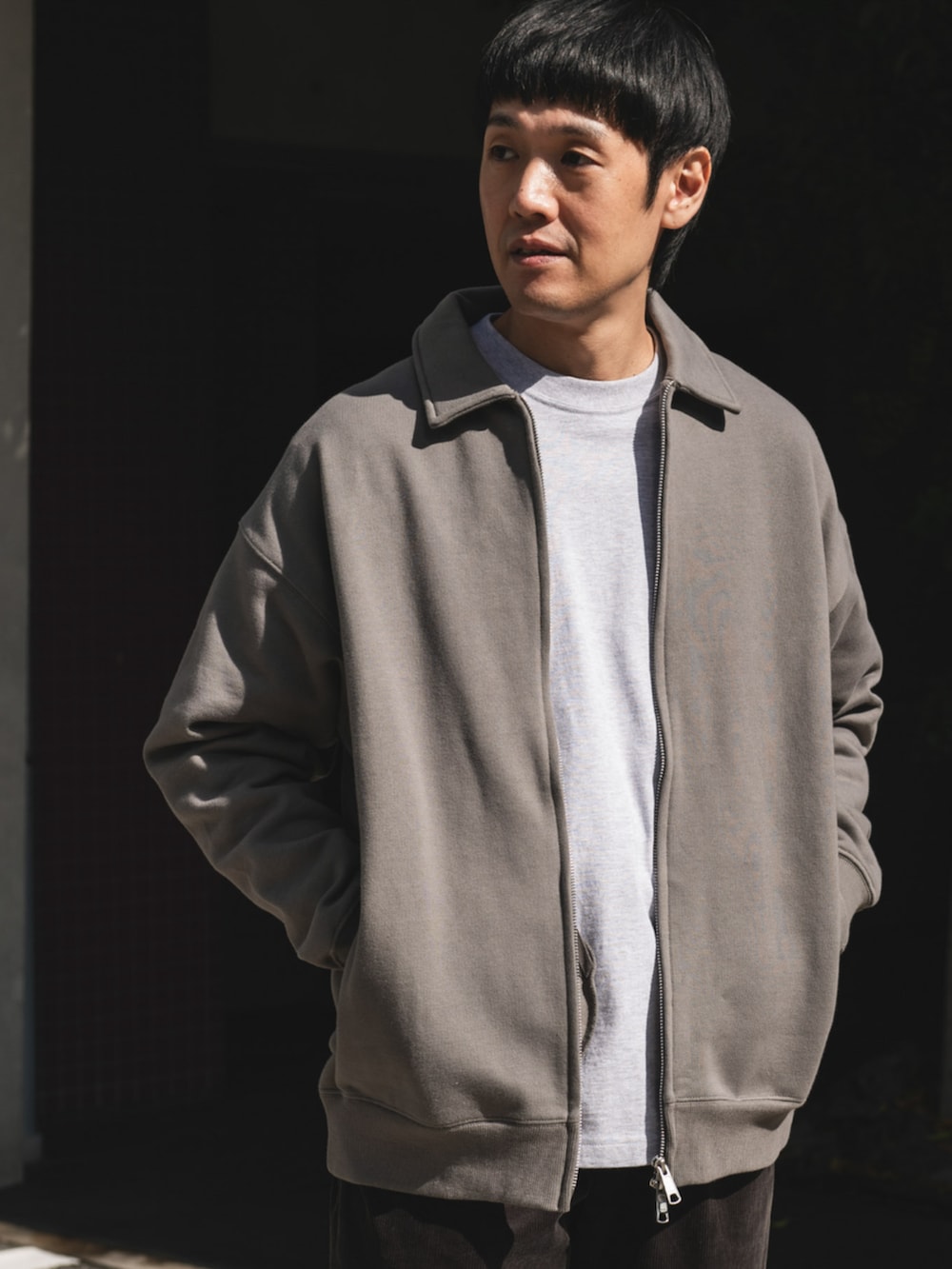 グレー系のブルゾン、ブラウン系のその他パンツを着用したメンズの秋コーディネートの2枚目の写真