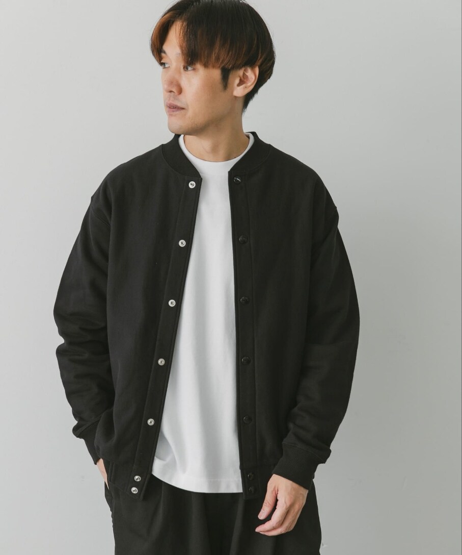 ブラック系のブルゾン、ホワイト系のTシャツ/カットソー、ブラック系のチノパンツを着用したメンズの秋コーディネートの2枚目の写真