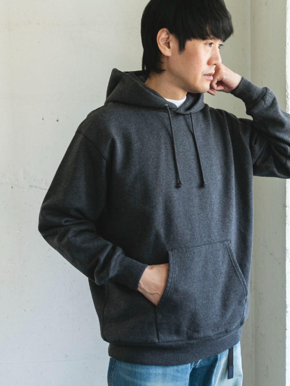 グレー系のパーカー、ブルー系のデニムパンツを着用したメンズの秋コーディネートの2枚目の写真