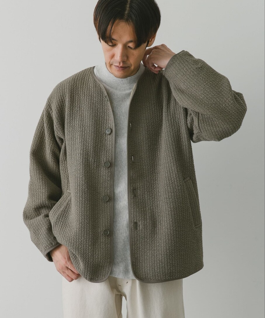 グリーン系のブルゾン、グレー系のTシャツ/カットソー、ホワイト系のデニムパンツを着用したメンズの秋コーディネートの2枚目の写真