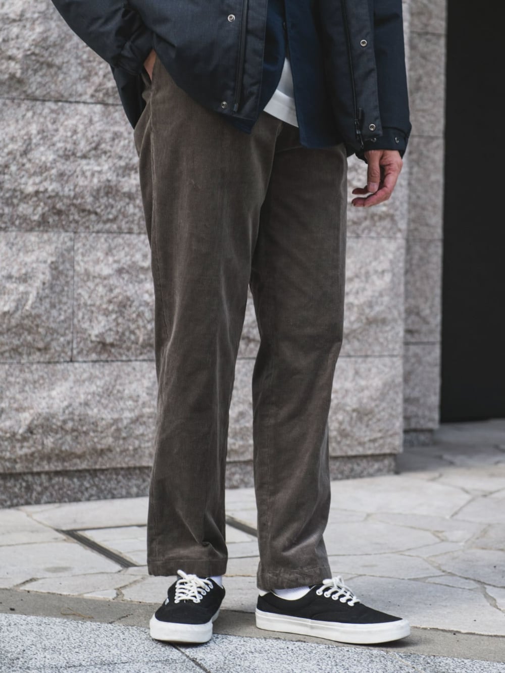 ブラウン系のその他パンツ、ブラック系のダウンジャケット/コート、ブルー系のシャツ/ブラウスを着用したメンズの冬コーディネートの2枚目の写真