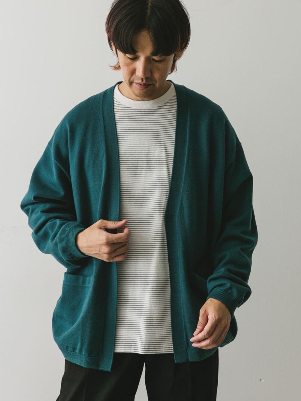 ブラック系のチノパンツ、グリーン系のカーディガン/ボレロ、ホワイト系のTシャツ/カットソーを着用したメンズの秋コーディネートの2枚目の写真