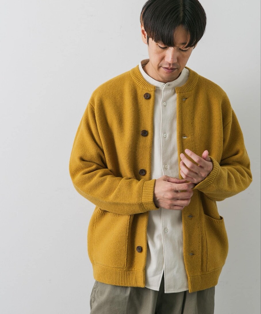 イエロー系のカーディガン/ボレロ、グリーン系のチノパンツを着用したメンズの秋コーディネートの2枚目の写真