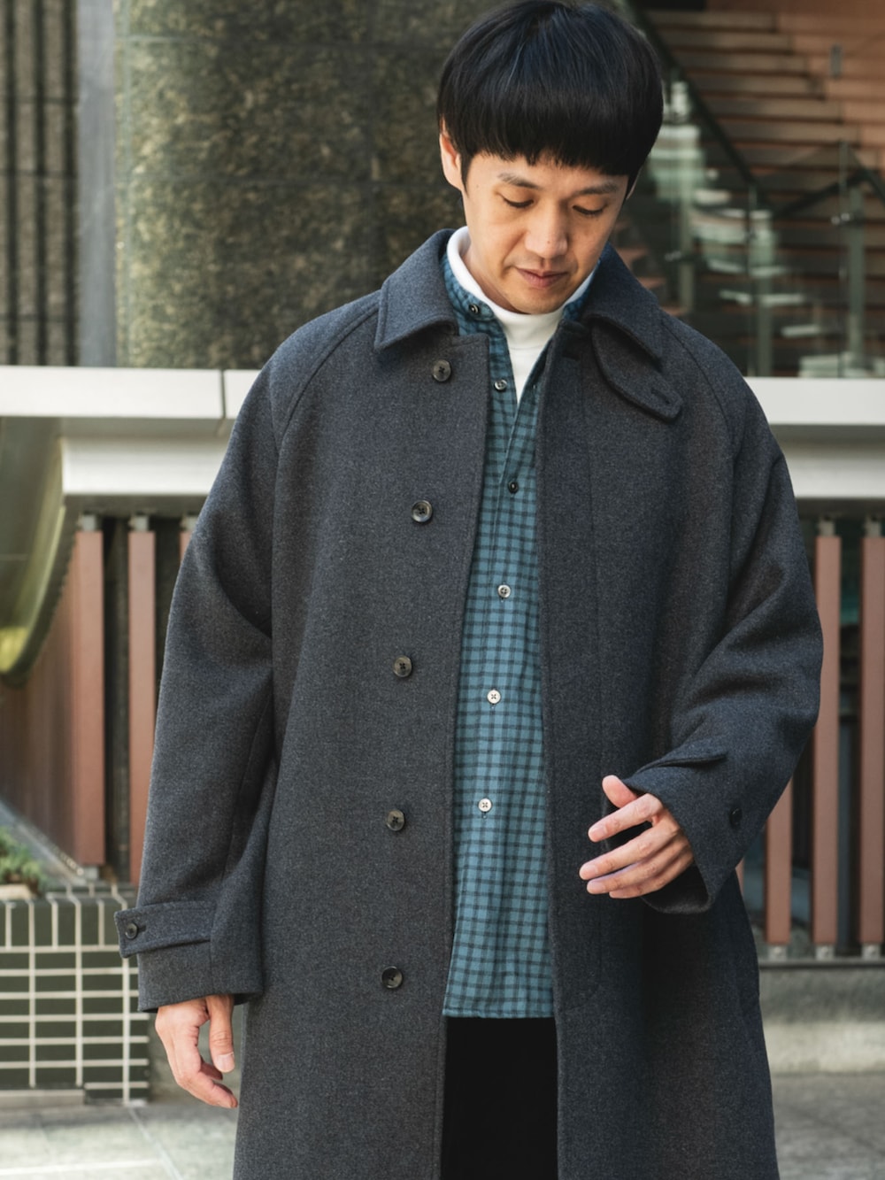 グレー系のステンカラーコートを着用したメンズの秋コーディネートの2枚目の写真