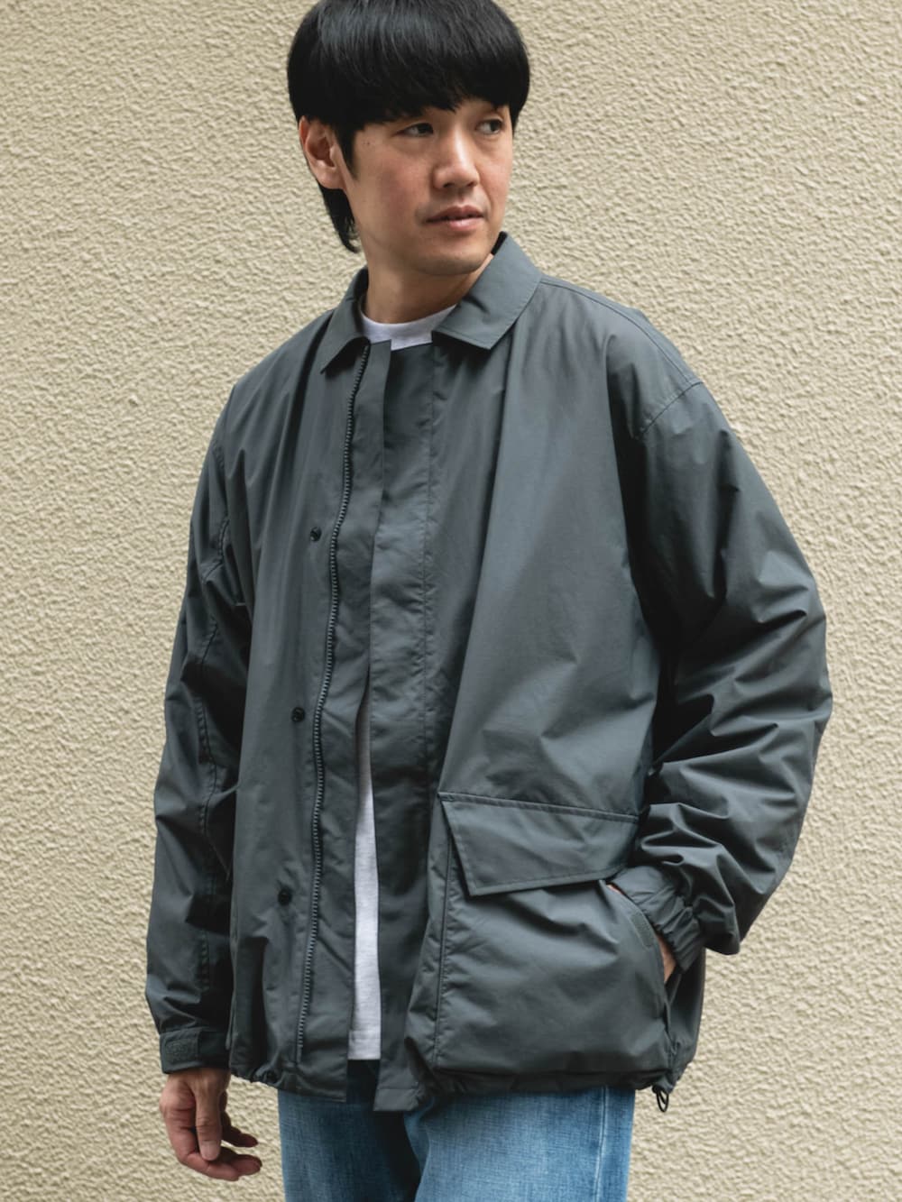 グレー系のナイロンジャケットを着用したメンズの秋コーディネートの2枚目の写真