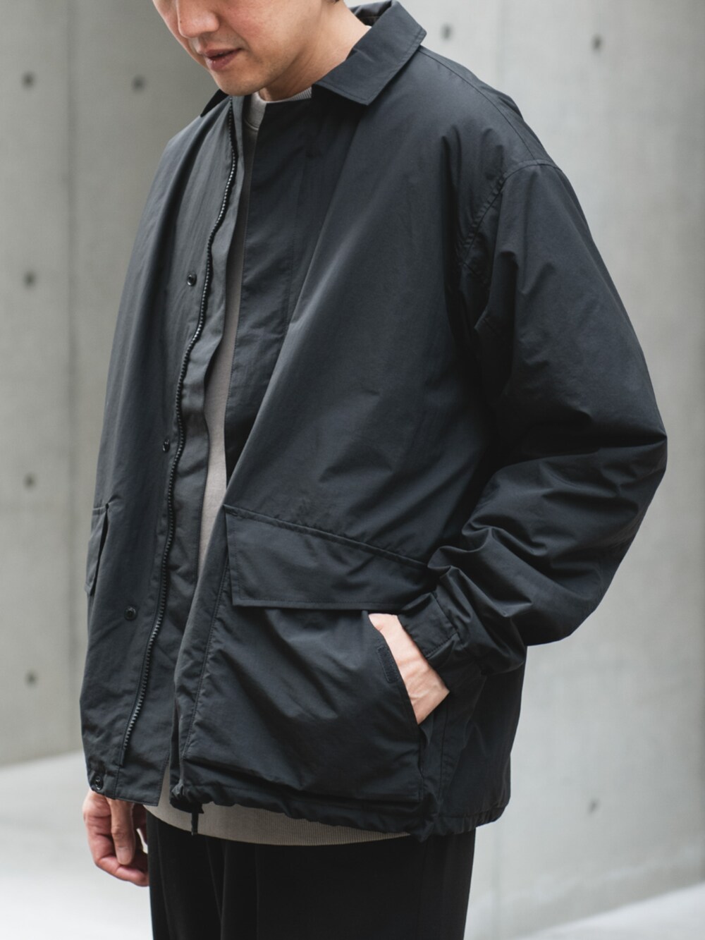 ブラック系のナイロンジャケットを着用したメンズの秋コーディネートの2枚目の写真