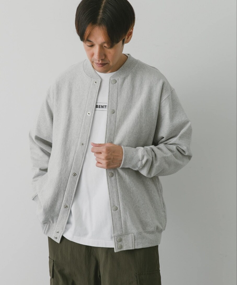 グレー系のブルゾン、ホワイト系のTシャツ/カットソー、グリーン系のカーゴパンツを着用したメンズの秋コーディネートの2枚目の写真