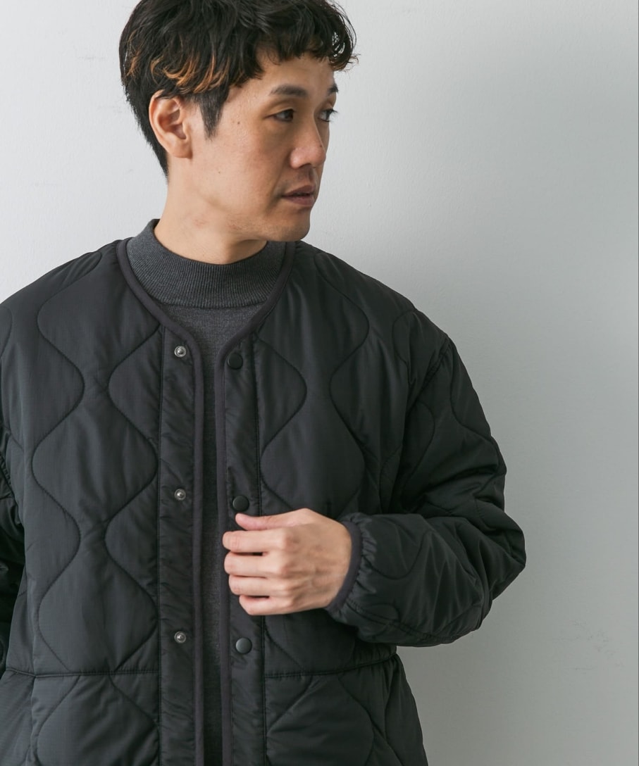 ブラック系のダウンジャケット/コート、グレー系のニット/セーター、ブラウン系のその他パンツを着用したメンズの秋コーディネートの2枚目の写真