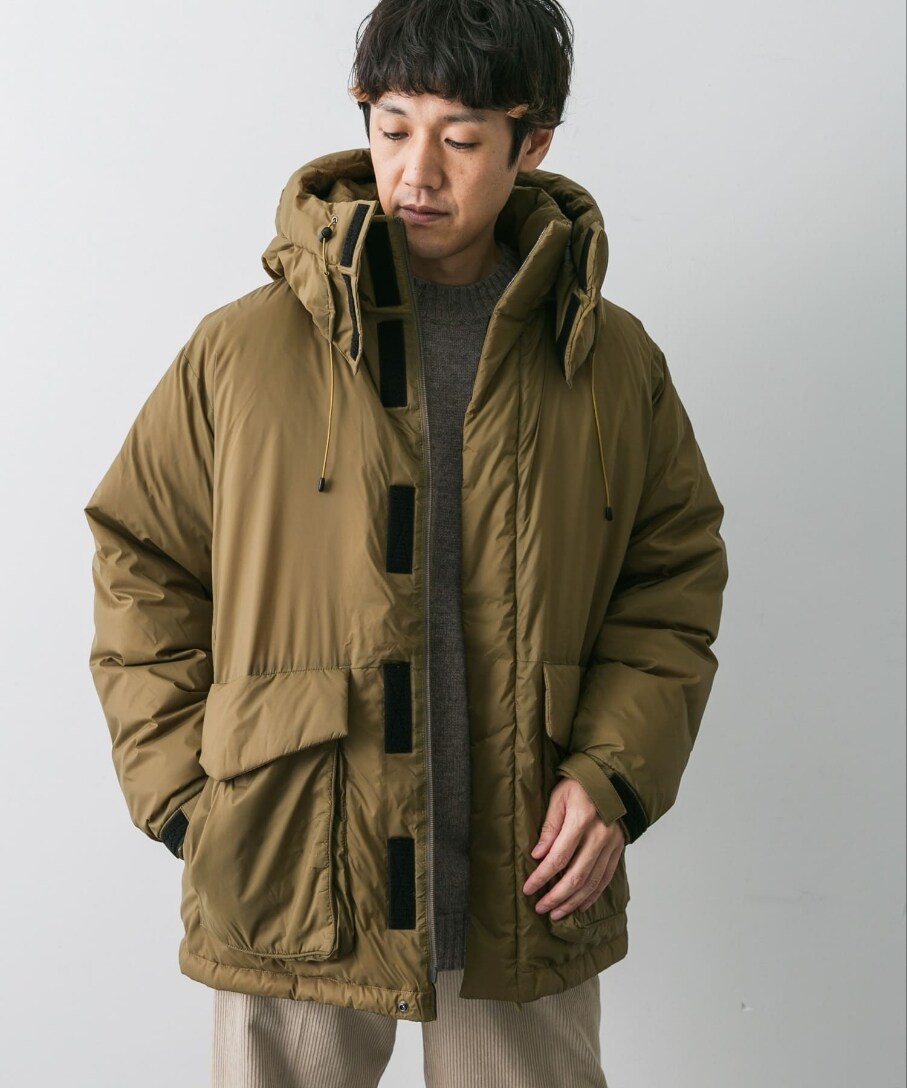 ブラウン系のダウンジャケット/コート、ブラウン系のニット/セーター、ホワイト系のその他パンツを着用したメンズの冬コーディネートの2枚目の写真