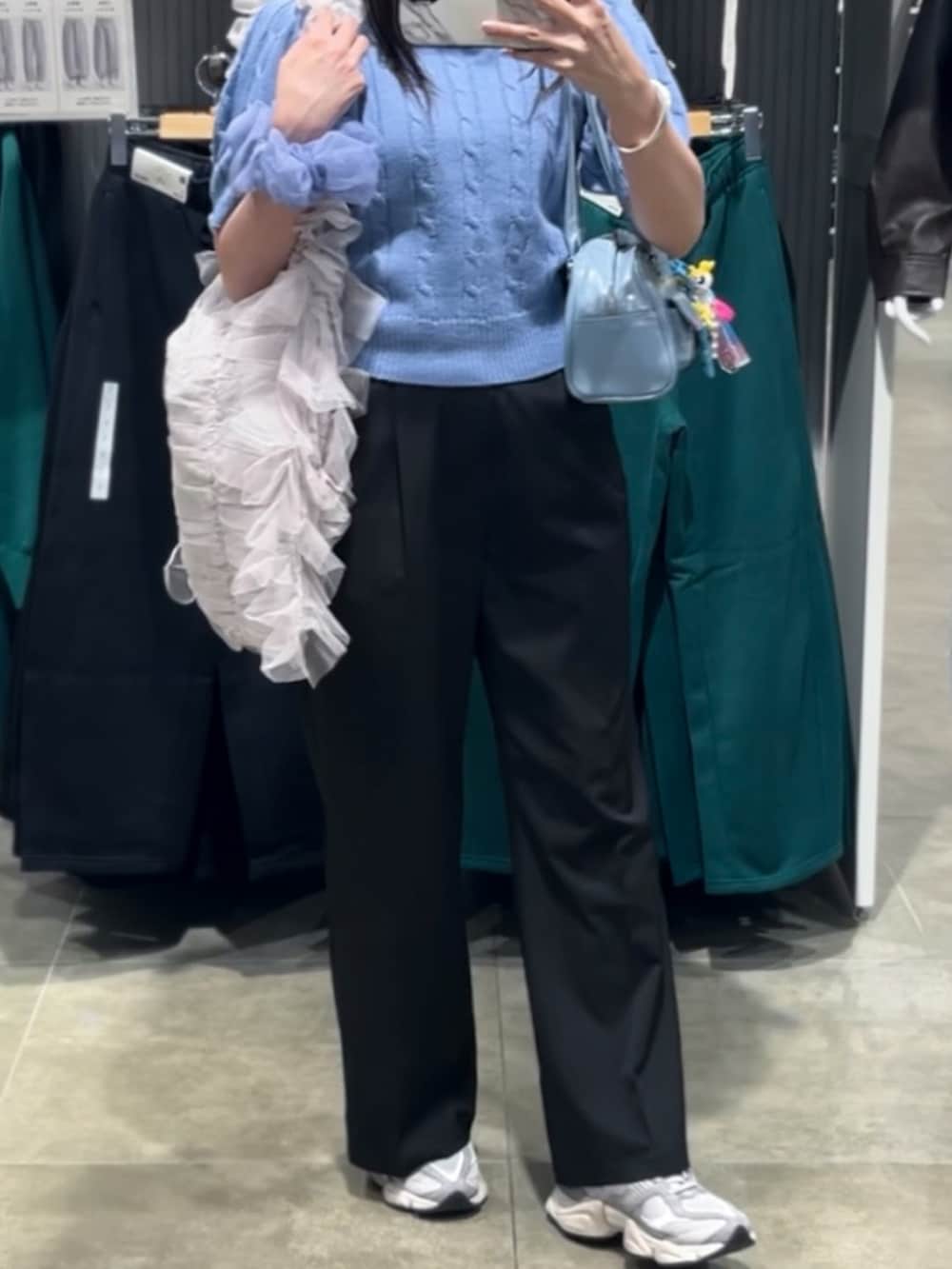 グレー系のスニーカー、ブルー系のショルダーバッグ、ブラック系のその他パンツを着用したレディースの秋コーディネートの2枚目の写真