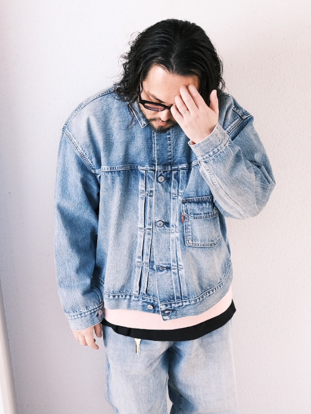 ブルー系のデニムジャケット、ピンク系のスウェット、ブルー系のデニムパンツを着用したメンズの春コーディネートの2枚目の写真