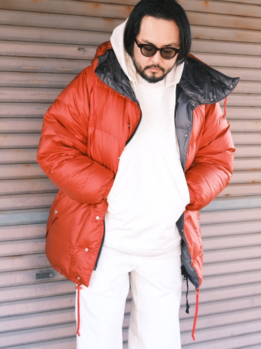 レッド系のダウンジャケット/コート、ホワイト系のパーカー、ホワイト系のスウェットパンツを着用したメンズの冬コーディネートの2枚目の写真