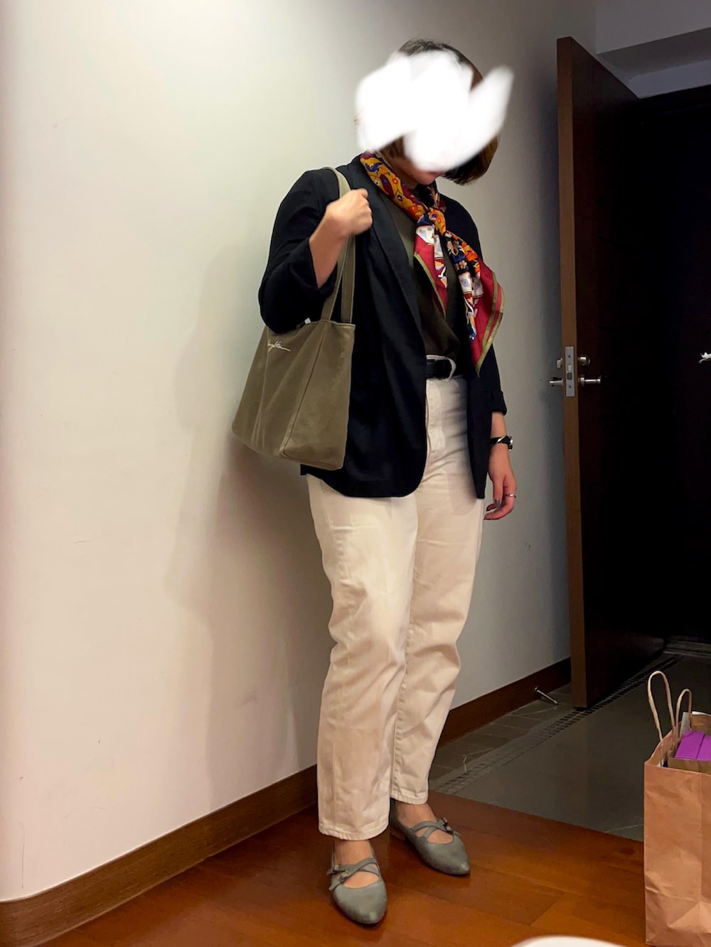 グリーン系のトートバッグ、ホワイト系のデニムパンツ、グリーン系のバレエシューズを着用したレディースの春コーディネートの2枚目の写真