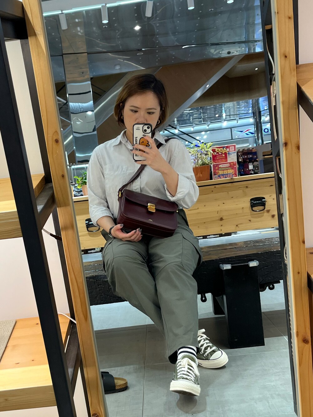 グリーン系のカーゴパンツ、ブラウン系のショルダーバッグ、グリーン系のスニーカーを着用したレディースの春コーディネートの2枚目の写真