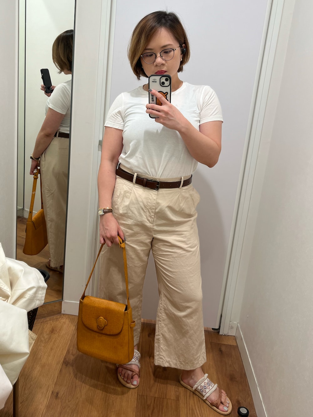 ベージュ系のその他パンツ、ホワイト系のTシャツ/カットソー、オレンジ系のショルダーバッグを着用したレディースの春コーディネートの2枚目の写真