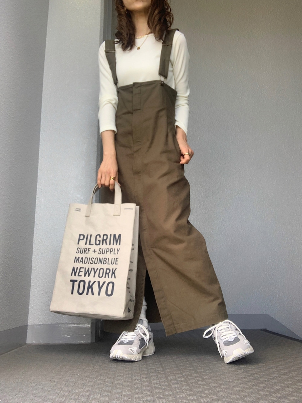 ホワイト系のTシャツ/カットソー、グレー系のスニーカーを着用したレディースの冬コーディネートの2枚目の写真