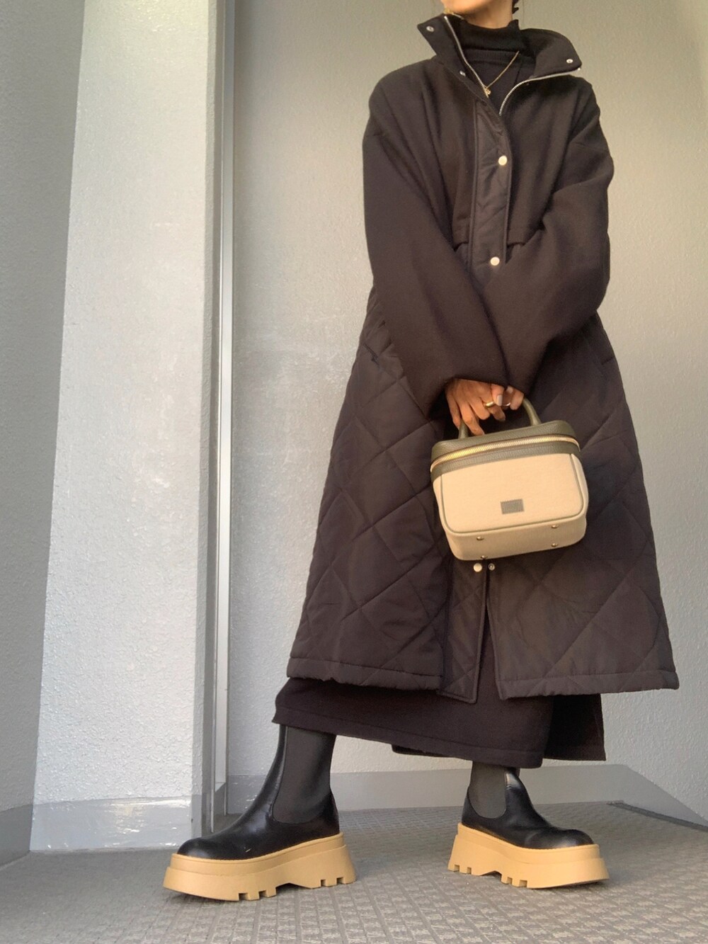 ブラック系のその他アウター、グリーン系のバッグ、ゴールド系のネックレスを着用したレディースの秋コーディネートの4枚目の写真