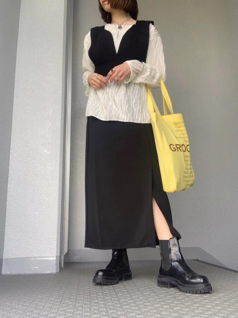 ホワイト系のTシャツ/カットソー、ブラック系のベスト、ブラック系のスカートを着用したレディースの春コーディネートの3枚目の写真