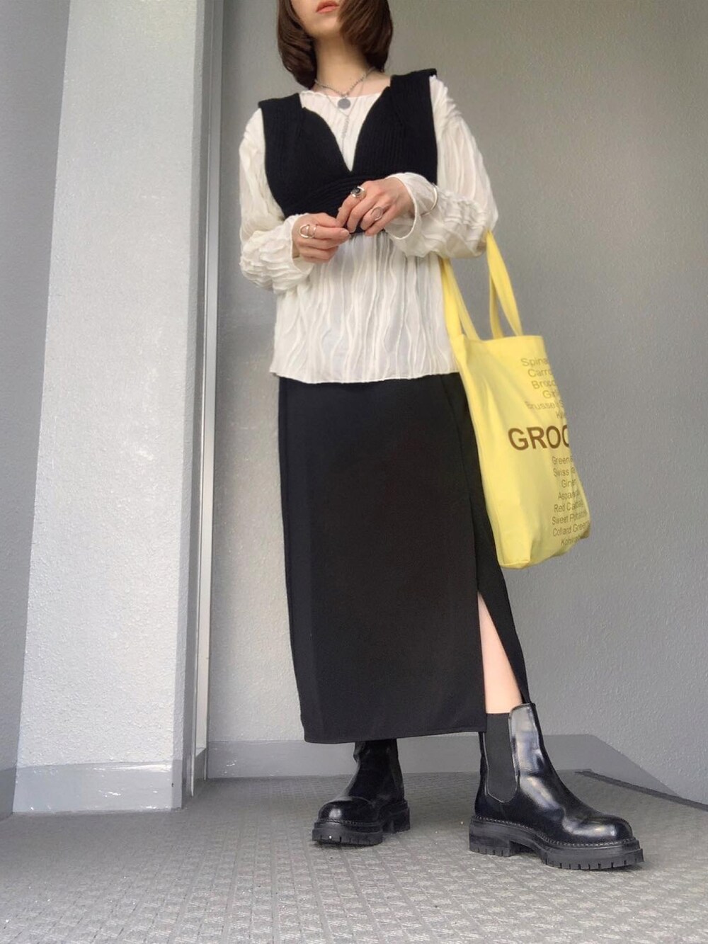 ホワイト系のTシャツ/カットソー、ブラック系のベスト、ブラック系のスカートを着用したレディースの春コーディネートの2枚目の写真