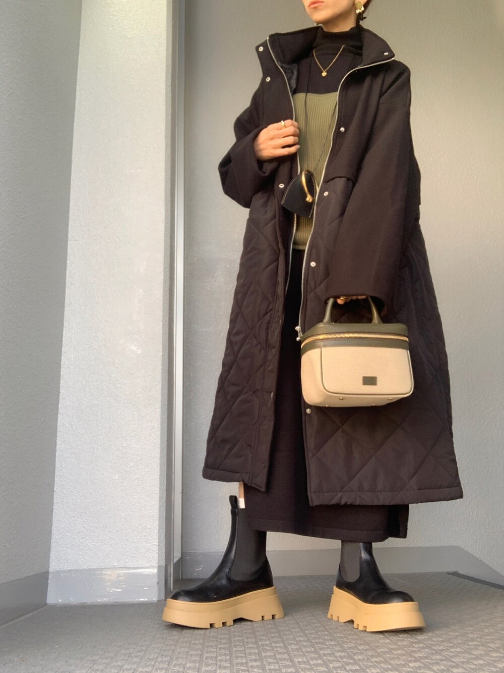 ブラック系のその他アウター、グリーン系のバッグ、ゴールド系のネックレスを着用したレディースの秋コーディネートの5枚目の写真