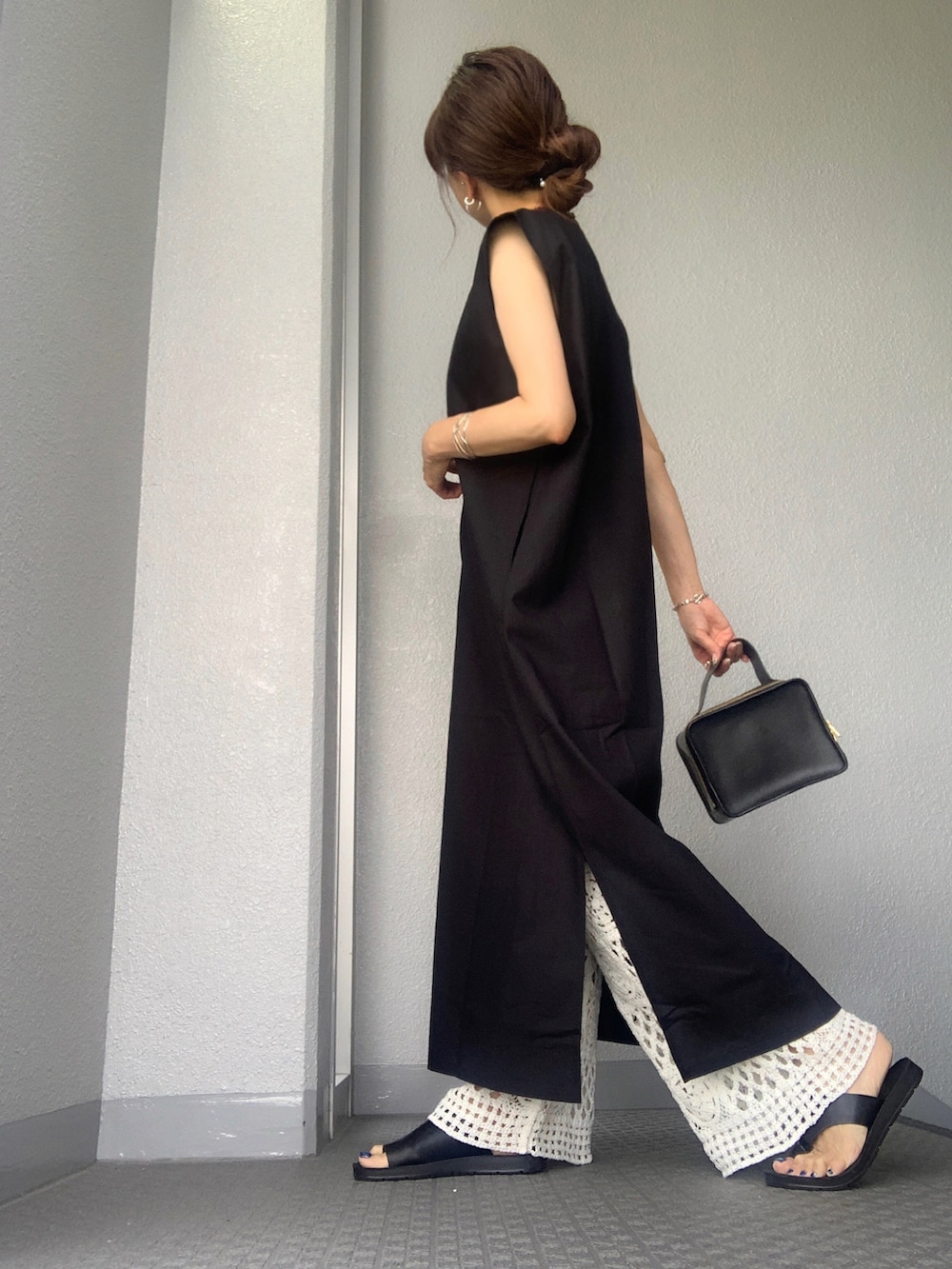 ブラック系のジャンパースカート、ホワイト系のその他パンツを着用したレディースの夏コーディネートの2枚目の写真