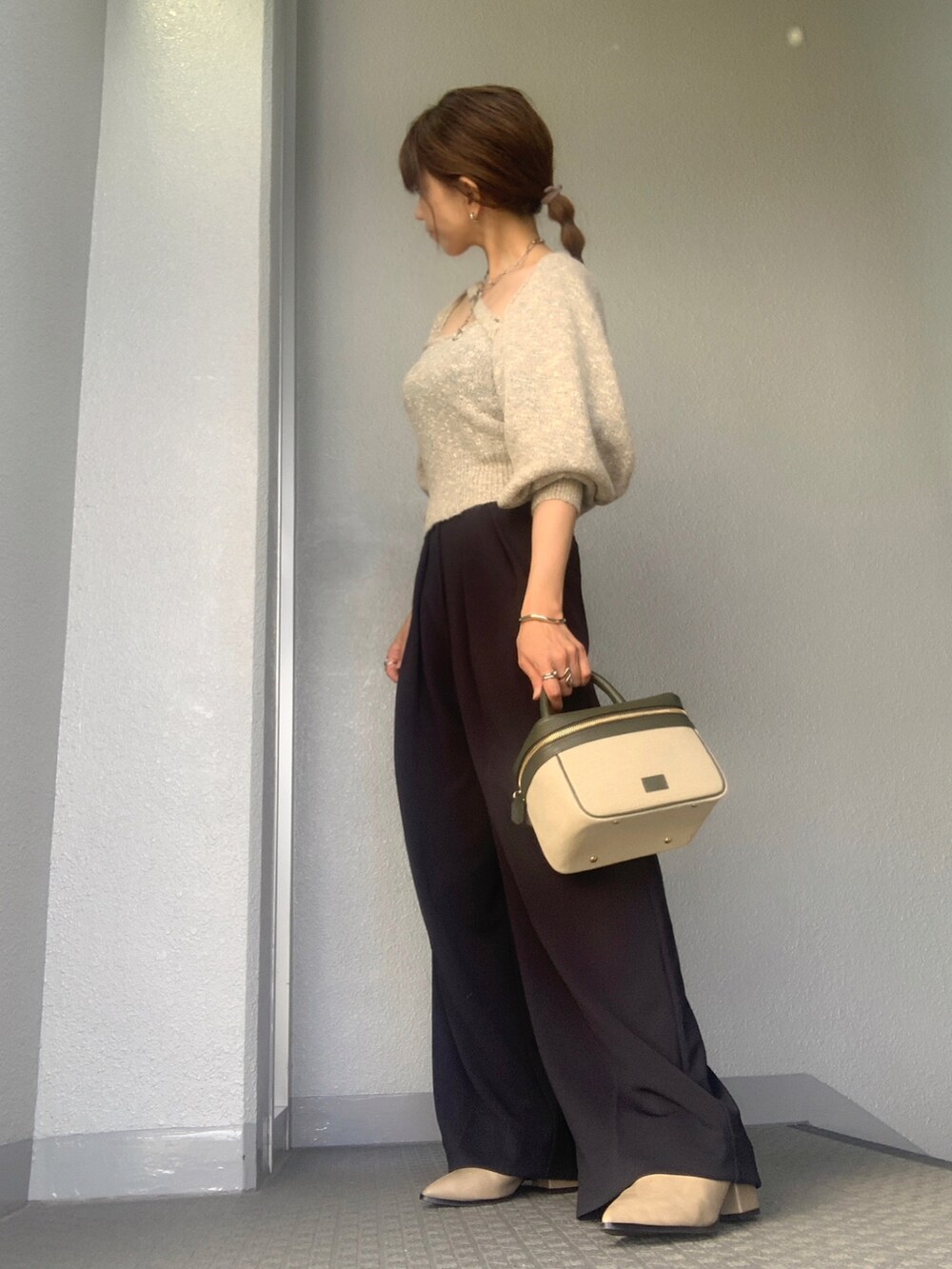 ブラック系のその他パンツ、グレー系のニット/セーター、グリーン系のバッグを着用したレディースの秋コーディネートの3枚目の写真