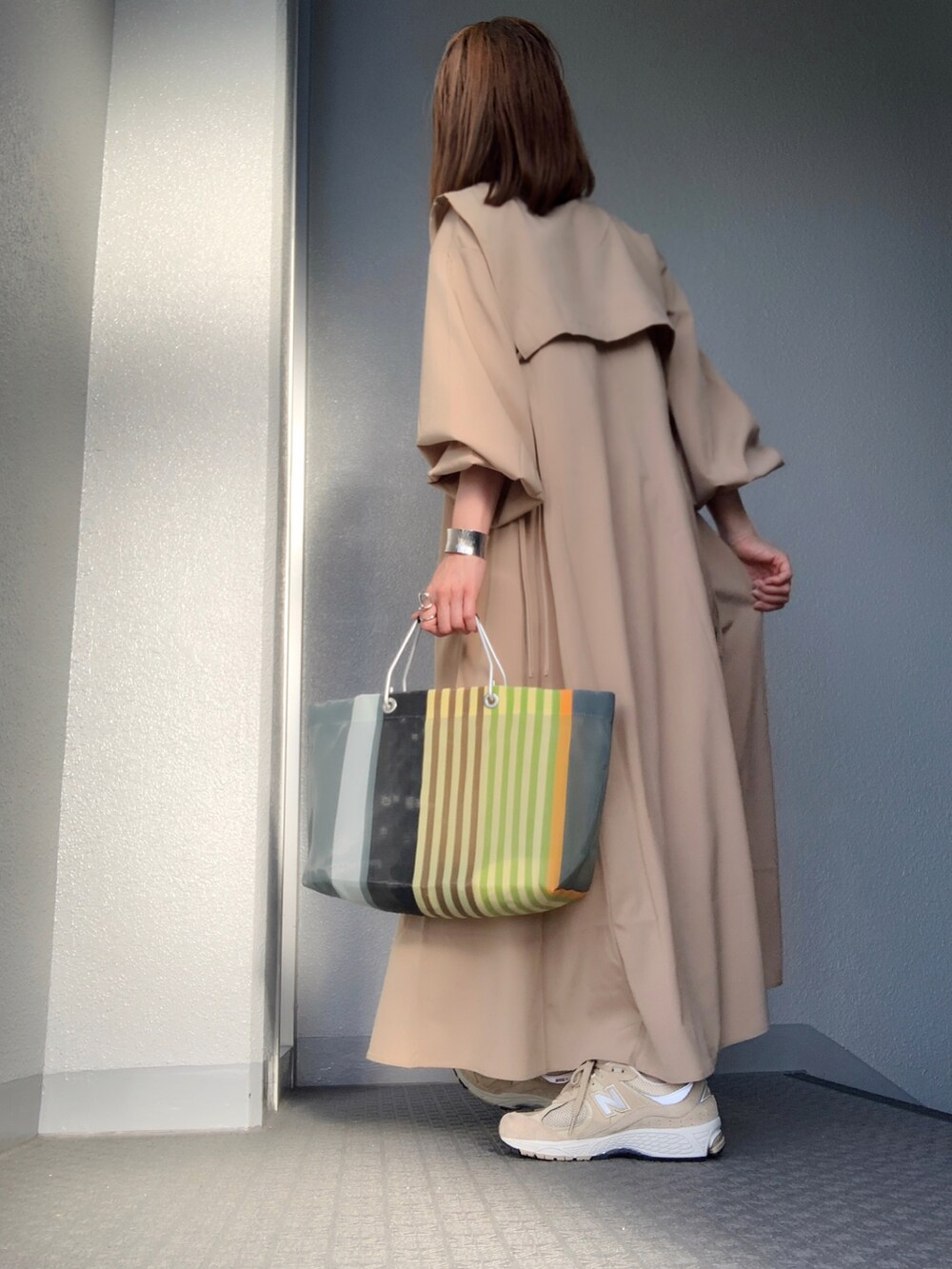 ベージュ系のシャツワンピース、その他のトートバッグ、ベージュ系のスニーカーを着用したレディースの春コーディネートの4枚目の写真