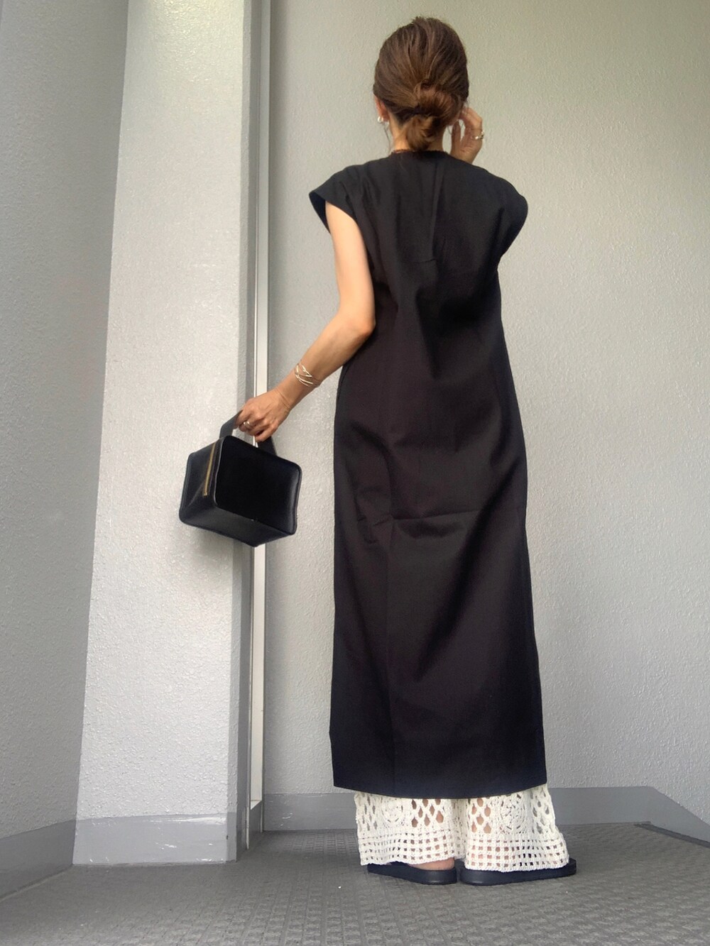 ブラック系のジャンパースカート、ホワイト系のその他パンツを着用したレディースの夏コーディネートの3枚目の写真