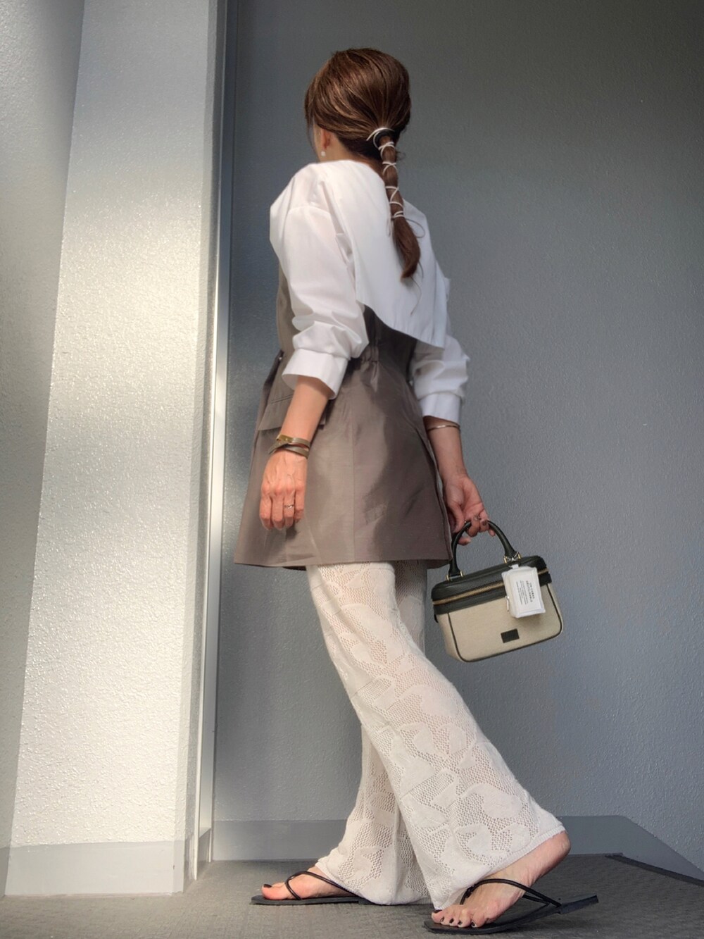 ベージュ系のキャミソール、グリーン系のバッグ、ホワイト系のエコバッグ/サブバッグを着用したレディースの春コーディネートの4枚目の写真
