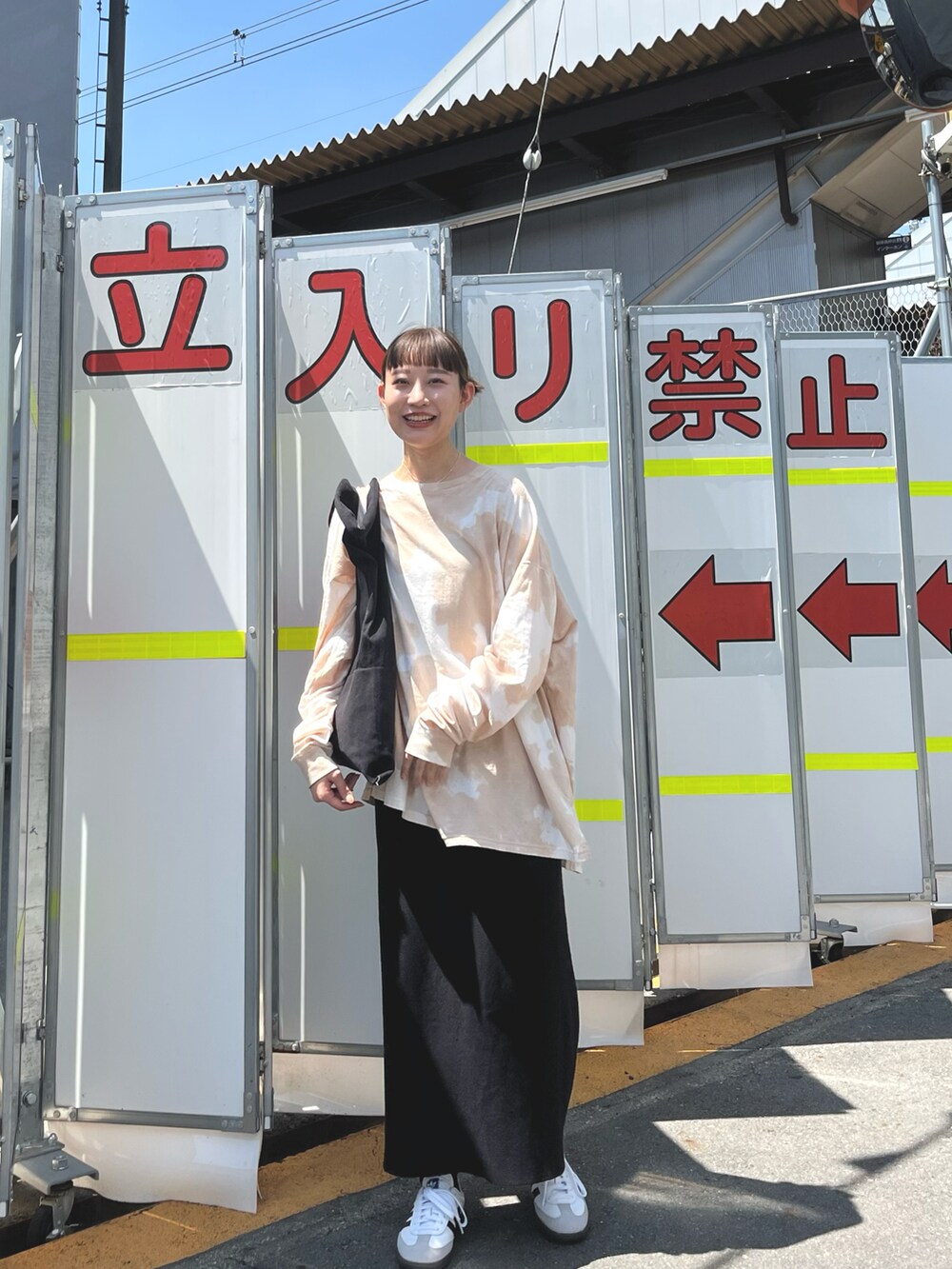 ホワイト系のスニーカー、ベージュ系のTシャツ/カットソー、ブラック系のバッグを着用したレディースの春コーディネートの3枚目の写真