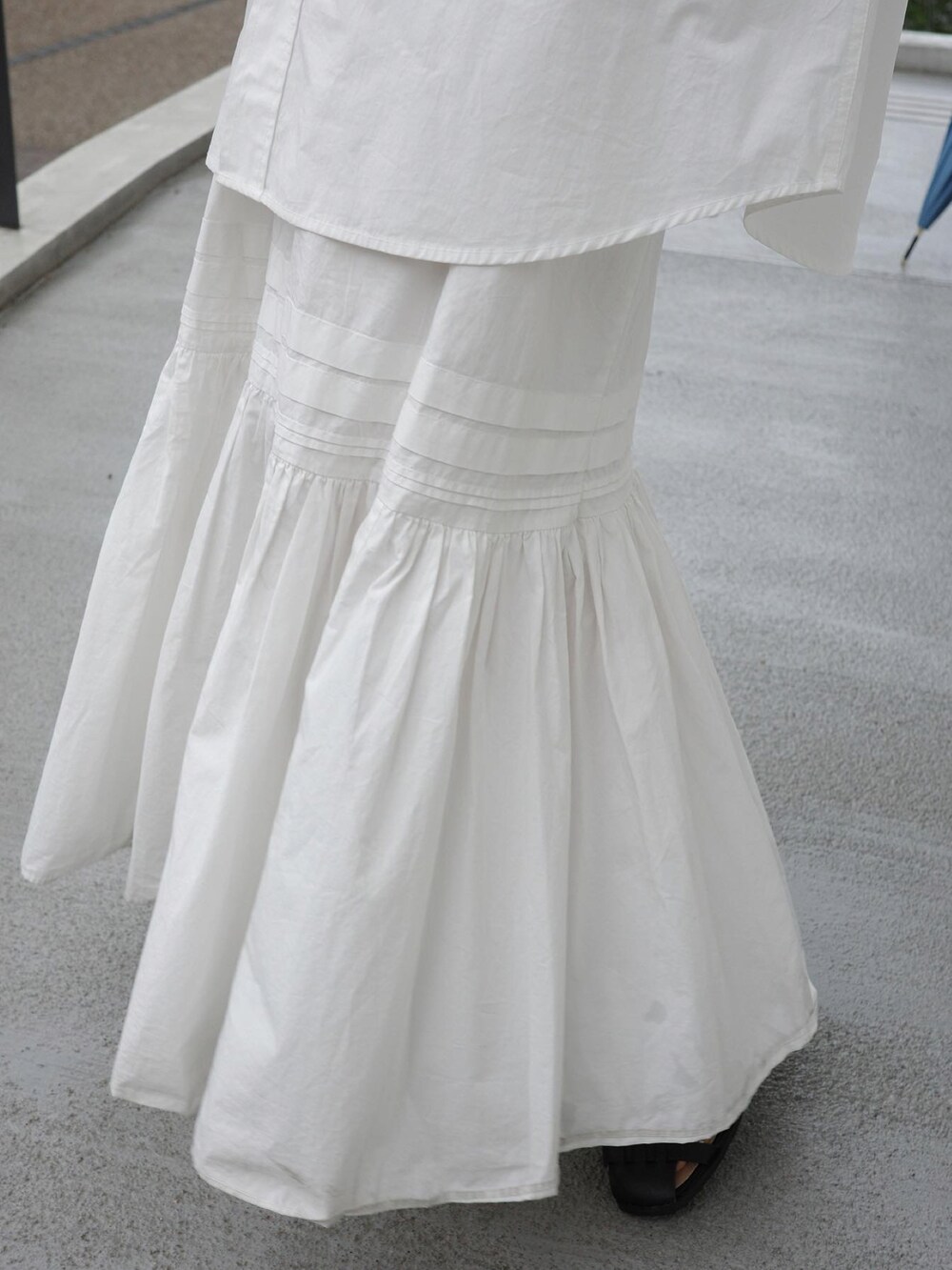 ホワイト系のシャツ/ブラウス、ホワイト系のスカート、ブラック系のハンドバッグを着用したレディースの春コーディネートの4枚目の写真