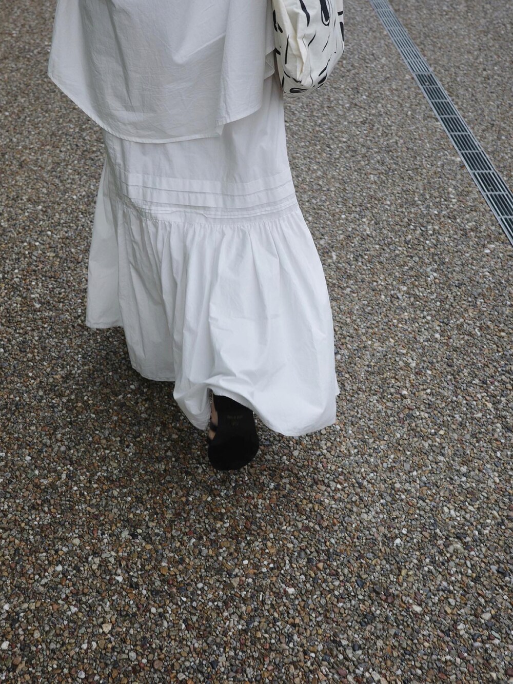 ホワイト系のシャツ/ブラウス、ホワイト系のスカート、ブラック系のハンドバッグを着用したレディースの春コーディネートの5枚目の写真